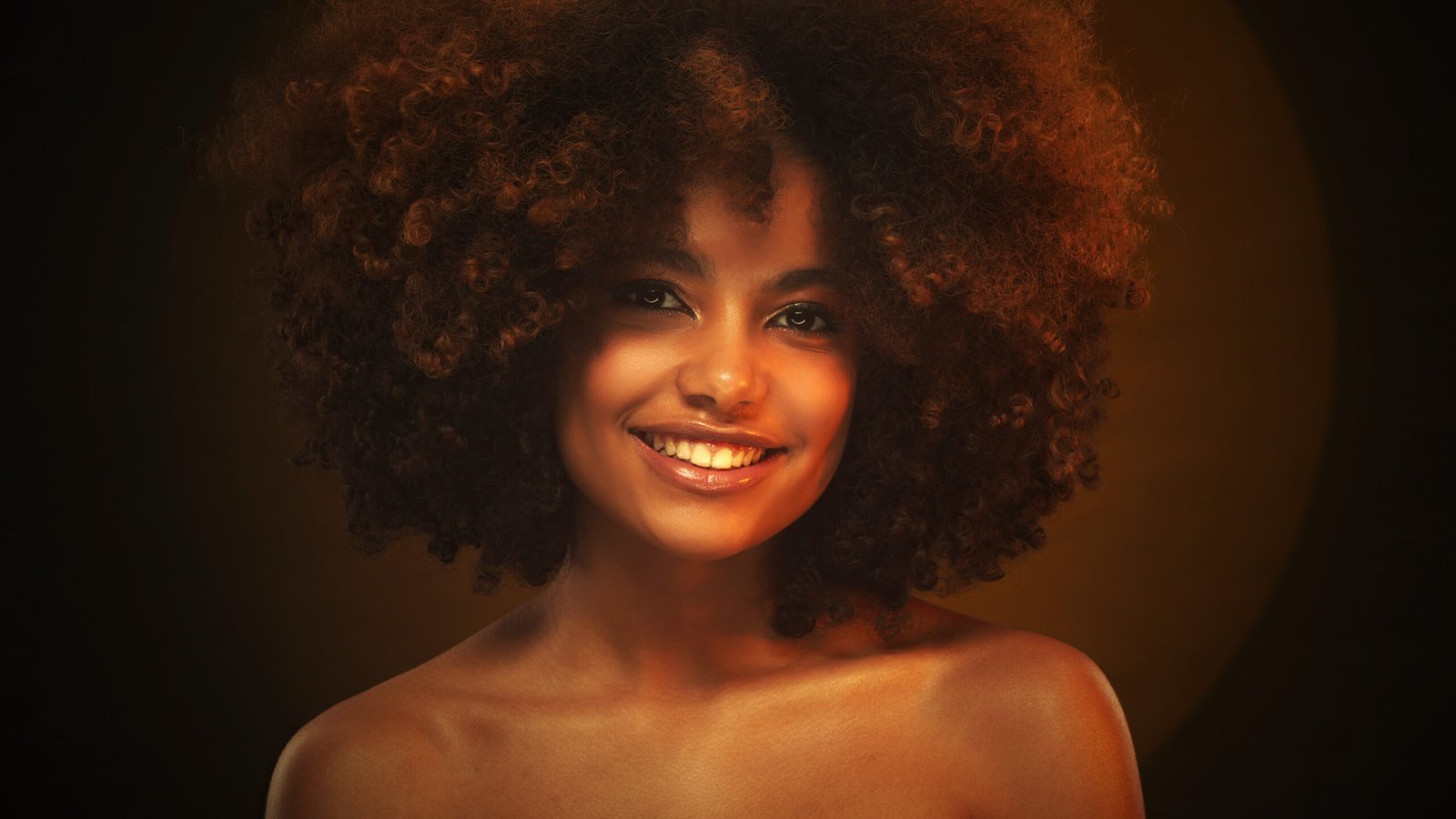 Studio portrait of smiling young beautiful african girl with afro hairstyle